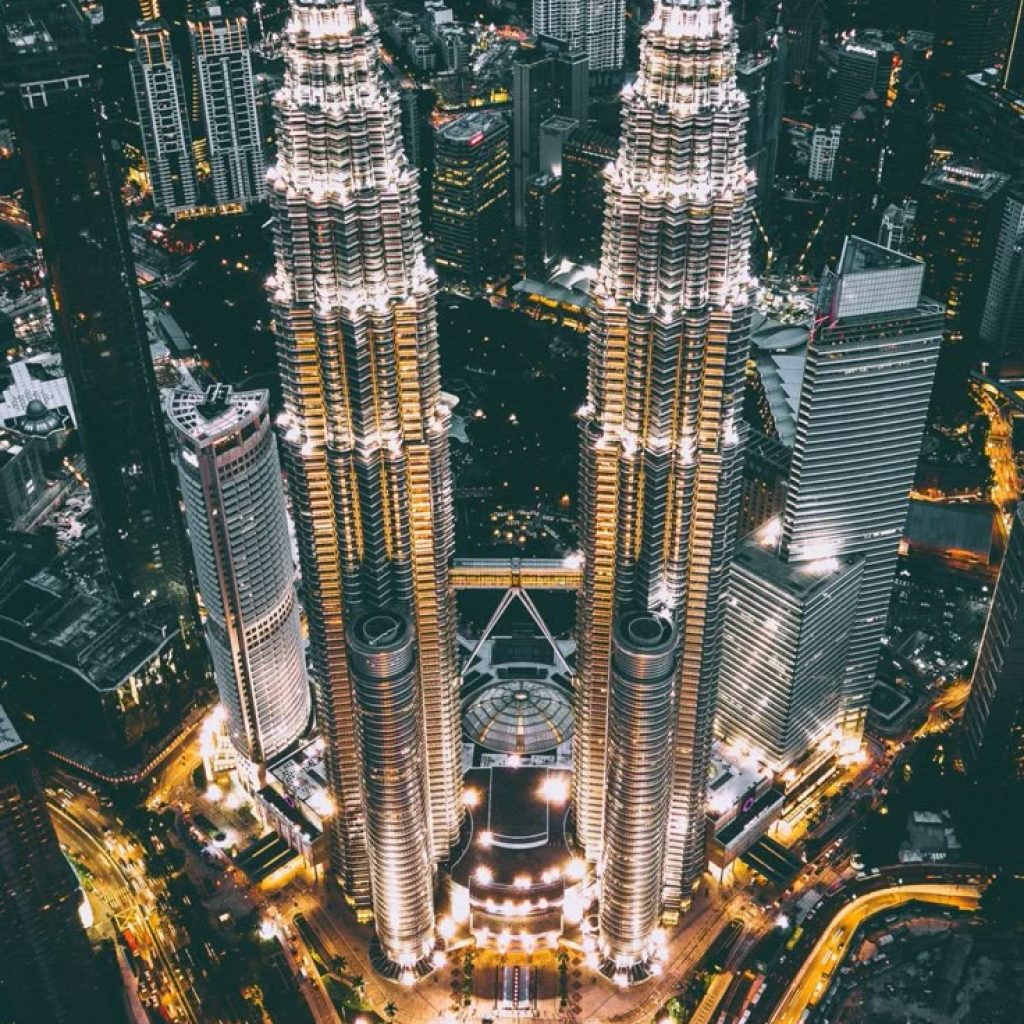 Vue panoramique sur les tours Petronas à Kuala Lumpur au coucher du soleil - Malaysia avec TraviaVoyages